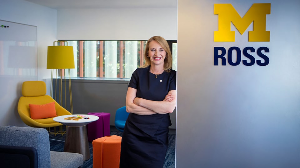 Dean Sharon Matusik next to a Block M with colorful furniture in the background.